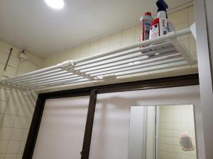 Una puerta de baño con ducha y un estante blanco encima. en Azami 7 Miyakojima, en Isla Miyako 52 fotos más