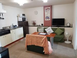 Una sala de estar con una mesa y una cocina. en Azami 7 Miyakojima, en Isla Miyako