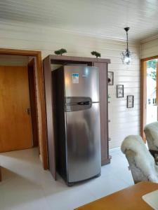 eine Küche mit einem Kühlschrank aus Edelstahl in einem Zimmer in der Unterkunft chalé do Riacho in Gramado