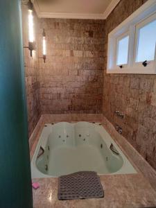 uma grande banheira na casa de banho com uma janela em chalé do Riacho em Gramado