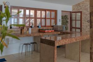 ルリンにあるMagnífica Casa de playa 3BRのキッチン(大きなカウンター、スツール付)