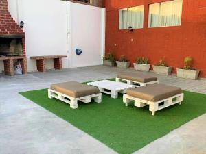 Magnífica Casa de playa 3BR في لورين: سريرين على رقعة من العشب بجوار مبنى
