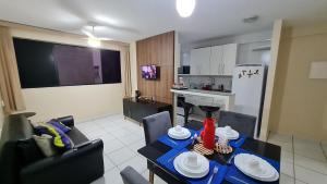 eine Küche und ein Wohnzimmer mit einem Tisch und Stühlen in der Unterkunft Ap Ponta Verde 290 mts da praia in Maceió