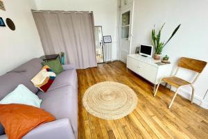 a living room with a couch and a desk at Peaceful studio nearby Paris in Pantin