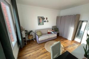 uma sala de estar com um sofá e uma mesa em Peaceful studio nearby Paris em Pantin