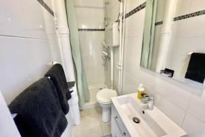 uma casa de banho branca com um lavatório e um WC em Peaceful studio nearby Paris em Pantin