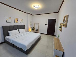 a bedroom with a large bed and a wooden table at Anda Betong Homestay in Ban Komo Sip Paet