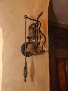 une cloche suspendue sur le côté d'un mur dans l'établissement Baroque villa near Bled - Resort Vidmar, à Lesce
