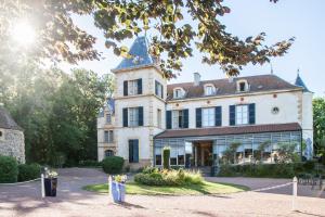 un gran edificio blanco con una torre en Château de Champlong Table Hôtel **** Golf & Spa en Villerest