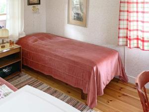a bedroom with a bed with a red blanket at Holiday home GRANGÄRDE II in Grangärde
