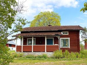 a small red house with a red roof at Holiday home GRANGÄRDE II in Grangärde