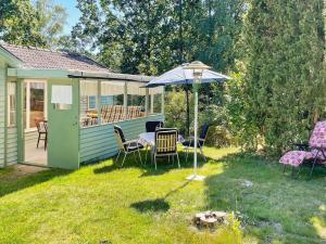 a patio with a table and an umbrella in a yard at Holiday home BERGKVARA X in Bergkvara