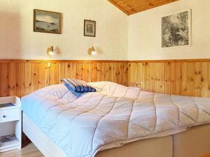 a large bed in a room with wooden walls at Holiday home BERGKVARA X in Bergkvara