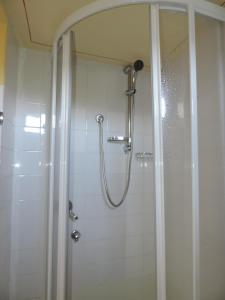 a shower with a glass door in a bathroom at Vanni's House in Cannobio