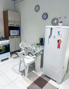 a kitchen with a table and a white refrigerator at Napolitan House in Manaus