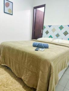 a bed with two blue pillows on top of it at Napolitan House in Manaus