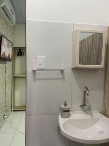 a white bathroom with a sink and a mirror at Napolitan House in Manaus +42 photos