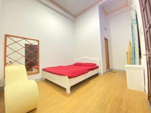 a bedroom with a bed with a red blanket and a chair at Homestay 888 in Bình Thủy