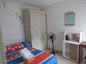 a bedroom with a bed and a desk with a fan at Precioso apartamento con piscina y wifi in Girardot