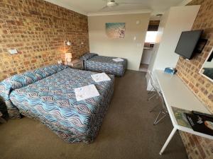 a hotel room with a bed and a couch at Golden Beach Motor Inn, Caloundra in Caloundra