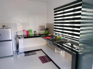 a kitchen with a sink and a refrigerator at Pangkor L29, Dream Island Homestay in Kampong Sungai Udang