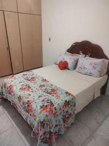 - une chambre avec un lit et une couette à fleurs dans l'établissement Aconchegante e especial, à Récife