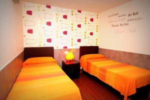 Dos camas en una habitación con una pared con escritura. en B&B Civico 16, en Nápoles