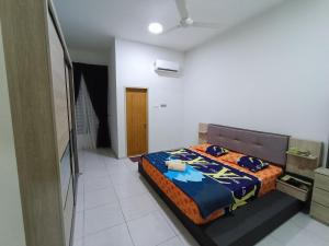 a bedroom with a bed in a white room at LOMPOI HOMESTAY Islam Guest in Merlimau