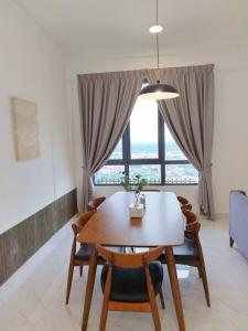ein Esstisch mit Stühlen und ein großes Fenster in der Unterkunft Troika Kota Bharu Penthouse Homestay 2 rooms in Kota Bharu
