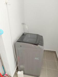 eine Waschmaschine in einer Ecke eines Zimmers in der Unterkunft Troika Kota Bharu Penthouse Homestay 2 rooms in Kota Bharu