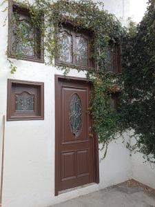 阿特利斯科的住宿－Casa Atlixco de las Flores，建筑物边有常春藤的棕色门