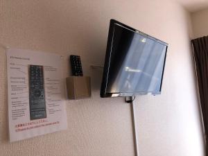 TV colgada en una pared con mando a distancia en I・ecoⅢ（アイエコスリー） en Niigata