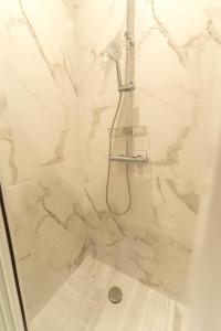 La salle de bains est pourvue d'une douche en marbre blanc. dans l'établissement AG 3 Sun Sand and serenity intimate, à Nice