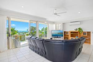 a large living room with a couch and a tv at Paradise View @ Bonny Hills in Bonny Hills