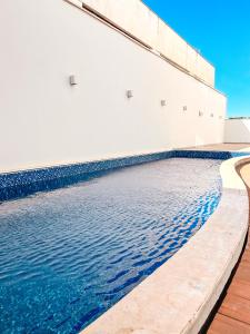 a pool of water next to a building at Portinari Palace Hotel in Vilhena