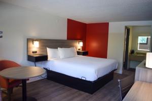 a hotel room with a large bed and a table at Ramada by Wyndham Cleveland Airport West in Fairview Park