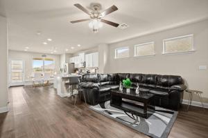 a living room with a black leather couch and a table at RoundRockLuxuryLivingW/GameRoom in Round Rock