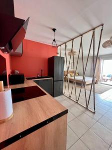 a kitchen with red walls and a kitchen with a counter at Bella Apartment in Fort-de-France