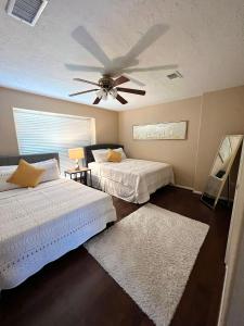 a bedroom with two beds and a ceiling fan at Spacious 2 Bedroom Townhome/ /15 min from downtown in Houston