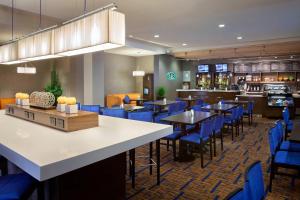 a restaurant with blue chairs and tables and a bar at Courtyard by Marriott Toronto Northeast/Markham in Markham