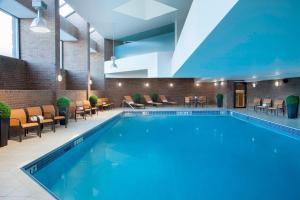 a pool in a hotel with chairs and tables at Courtyard by Marriott Toronto Northeast/Markham in Markham