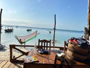 uma rede de descanso e uma mesa com vista para o oceano em Juani beach bungalows em Kilindoni