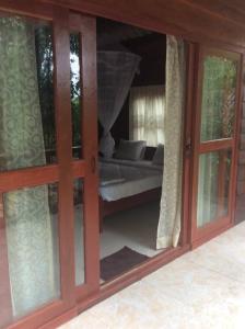 a sliding glass door with a bed in a room at Sambath Sakseth Bungalow in Koh Rong Island
