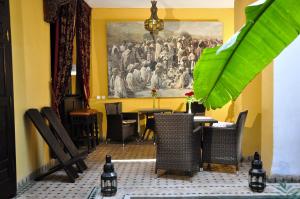 a dining room with a painting on the wall at Riad Aguaviva in Marrakech