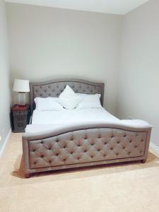 una camera da letto con un grande letto con lenzuola bianche di Large Luxury 4 Bed Guest House In King City a King City