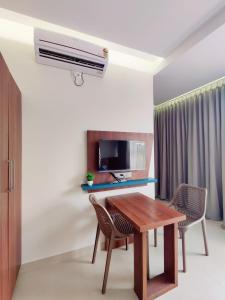 a living room with a table and a air conditioner at Hotel Royal Inn Lodge Dharwad in Dhārwād