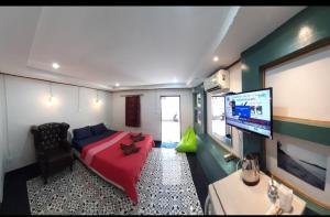 een slaapkamer met een bed en een flatscreen-tv bij คิวทอง บังกะโล (Q-Thong bungalow) in Ko Larn
