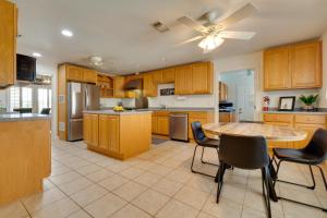 a kitchen with wooden cabinets and a table and chairs at 1-Story Hill Country Home Near Fiesta with Pool! in San Antonio