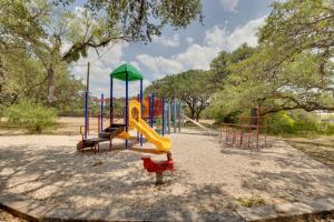 a playground with a slide in a park at 1-Story Hill Country Home Near Fiesta with Pool! in San Antonio