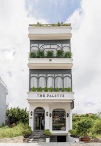 大叻的住宿－The Palette Dalat，一座高大的白色建筑,上面有标志